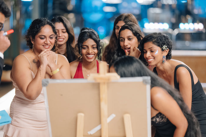 Friends gathered around an easel at a Marraké event
